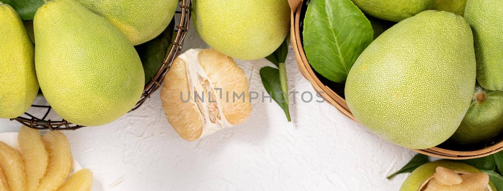 Fresh peeled pomelo, pummelo, grapefruit, shaddock on bright wooden background. Autumn seasonal fruit, top view, flat lay, tabletop shot.
