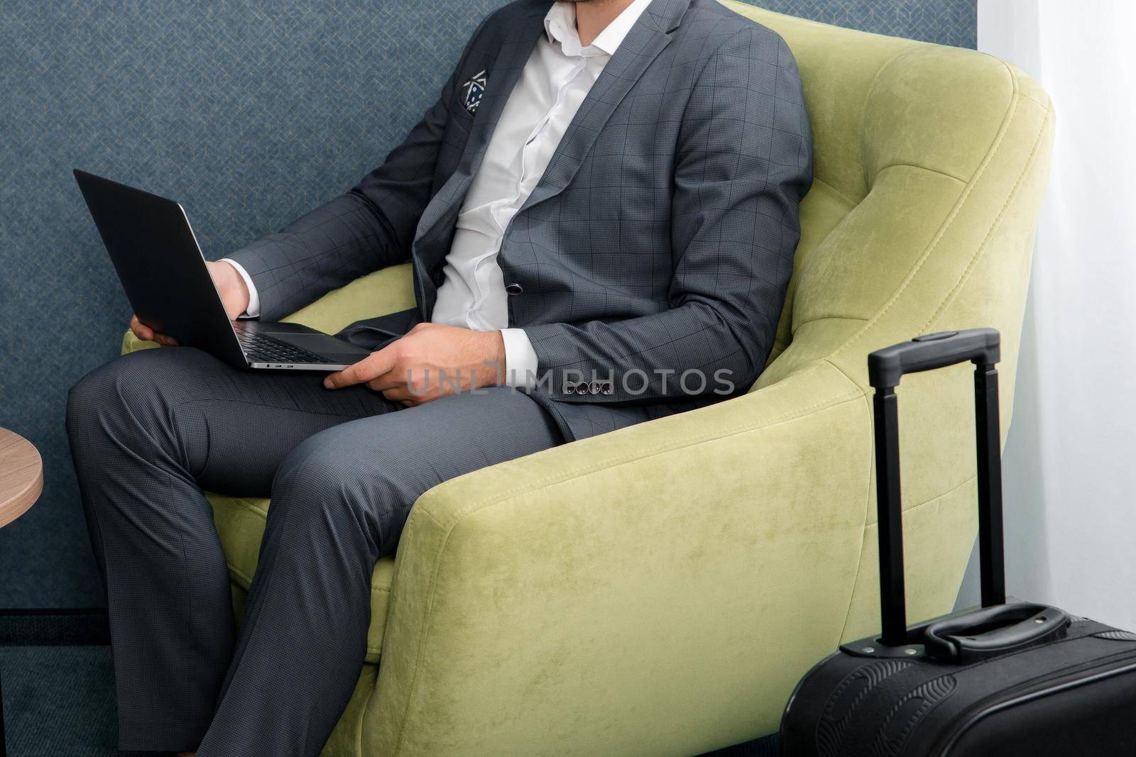Young businessman working on laptop, sitting in hotel