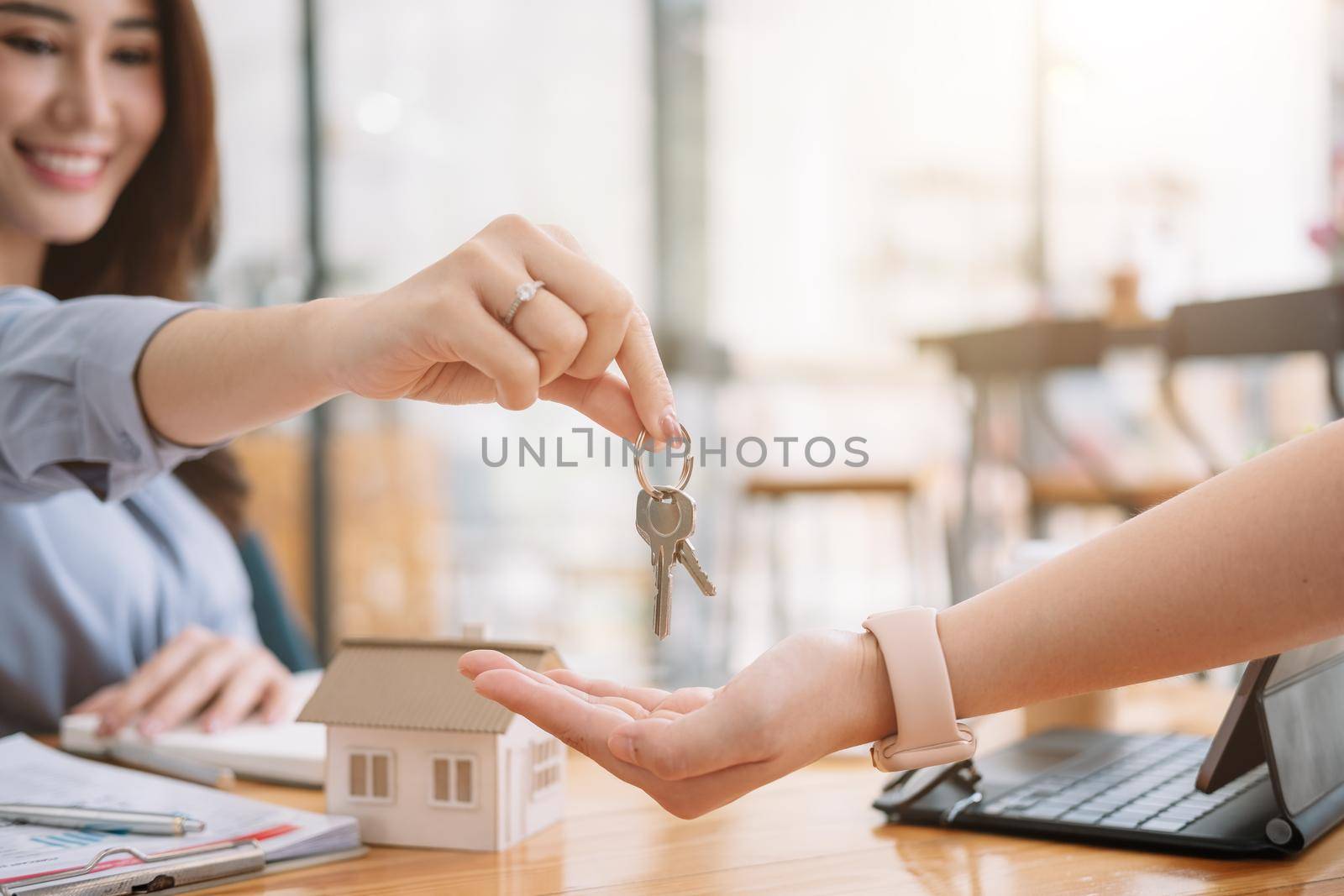 Client taking keys from female real estate agent during meeting after signing rental lease contract or sale purchase agreement. Independent woman purchasing new home, close up view