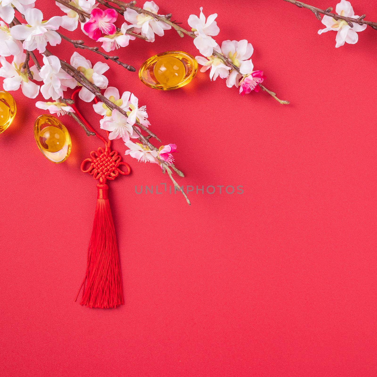 Design concept of Chinese lunar new year - Beautiful Chinese knot with plum blossom isolated on red background, flat lay, top view, overhead layout.