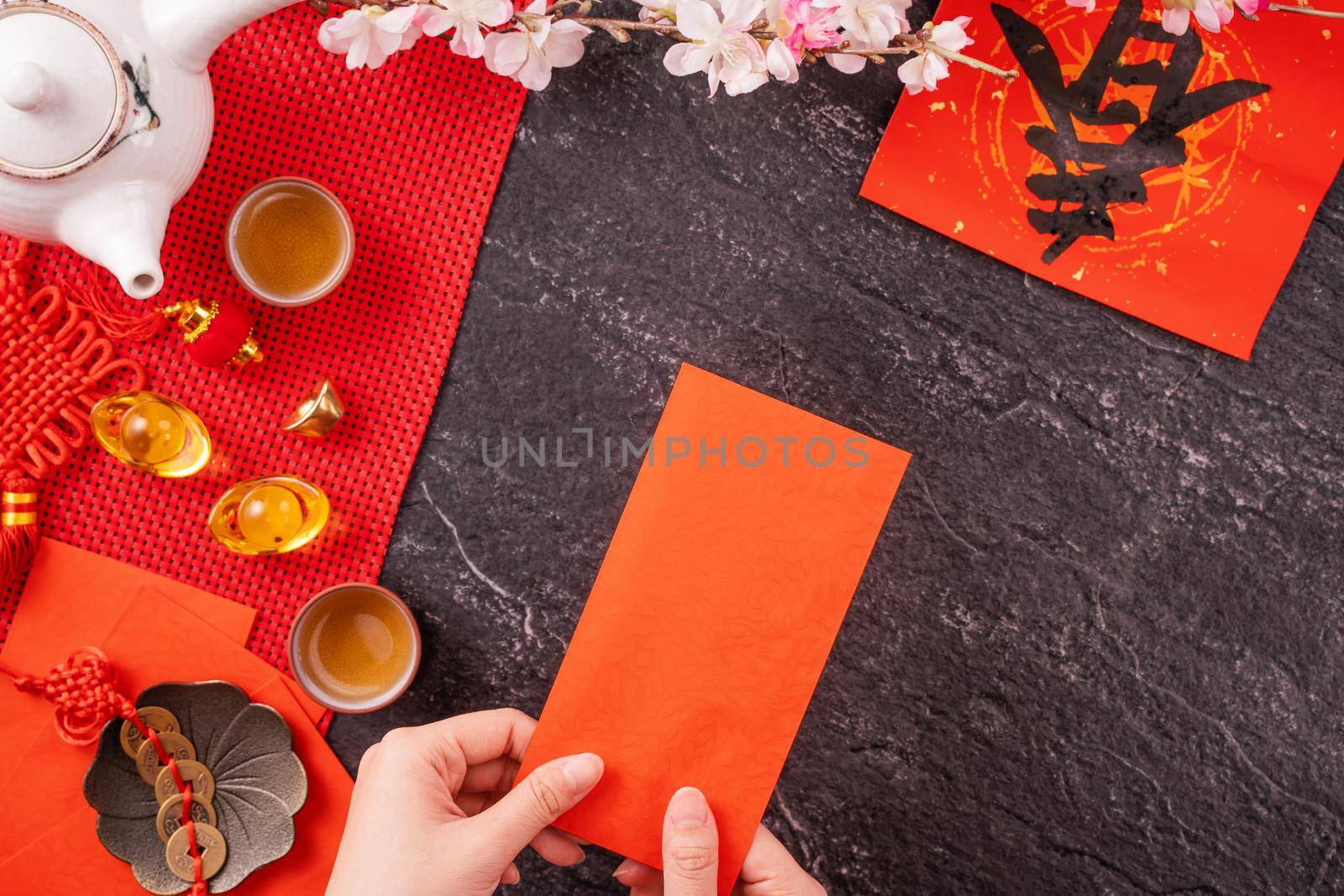 Design concept of Chinese lunar January new year - Woman holding, giving red envelopes (ang pow, hong bao) for lucky money, top view, flat lay, overhead above. The word 'chun' means coming spring.