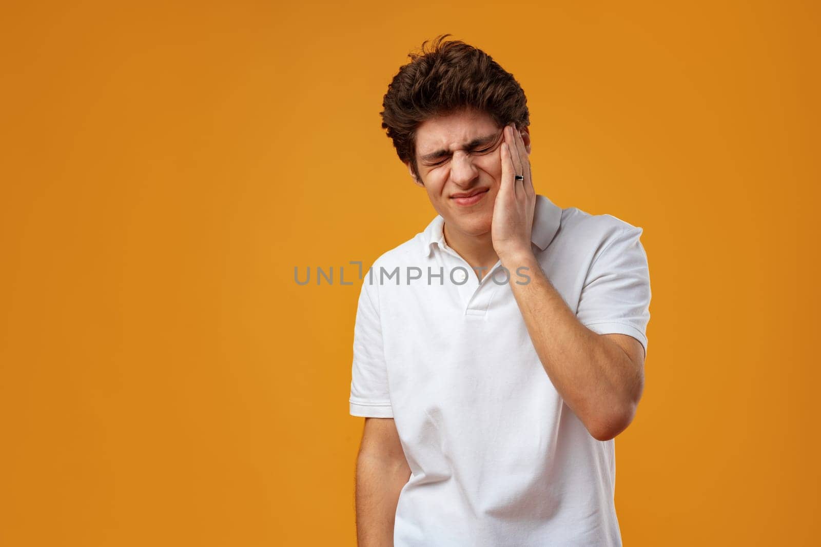 Young handsome man over yellow background touching mouth with hand suffering toothache
