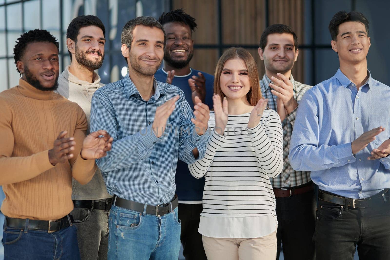 Human resources. Group portrait of smiling employees of a friendly team of different racial genders standing together in an office.