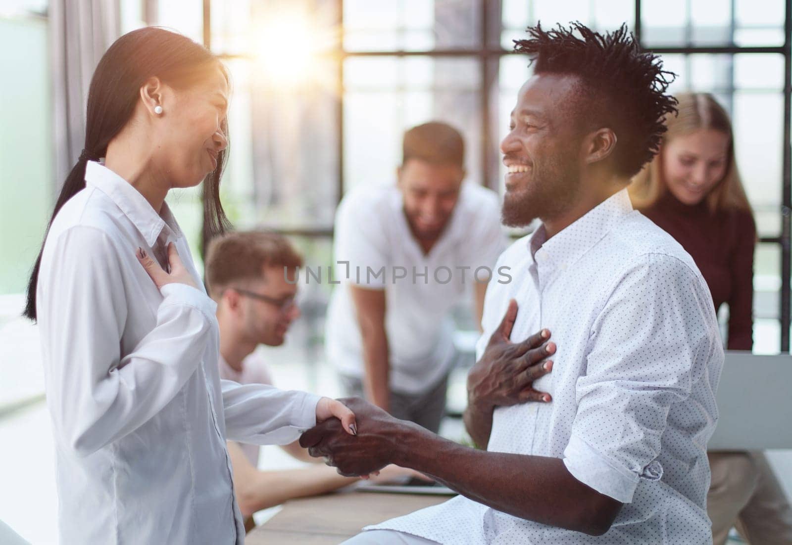Welcome to our team Handshake while working in a creative office. Success concept
