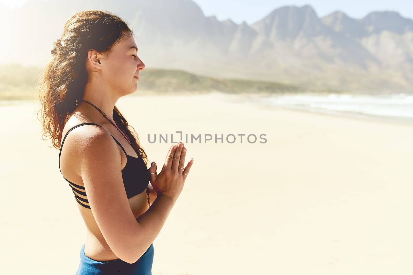 Yoga is one of my favorite forms of exercise. a beautiful young woman practising yoga on the beach. by YuriArcurs