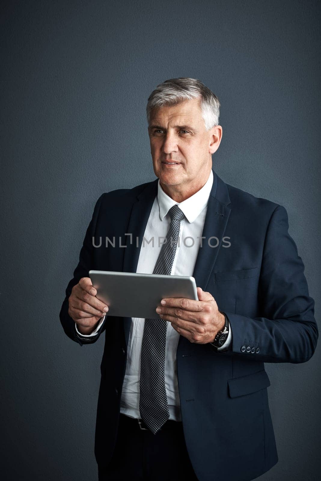 This is where the money lies. Studio shot of a mature businessman using his digital tablet