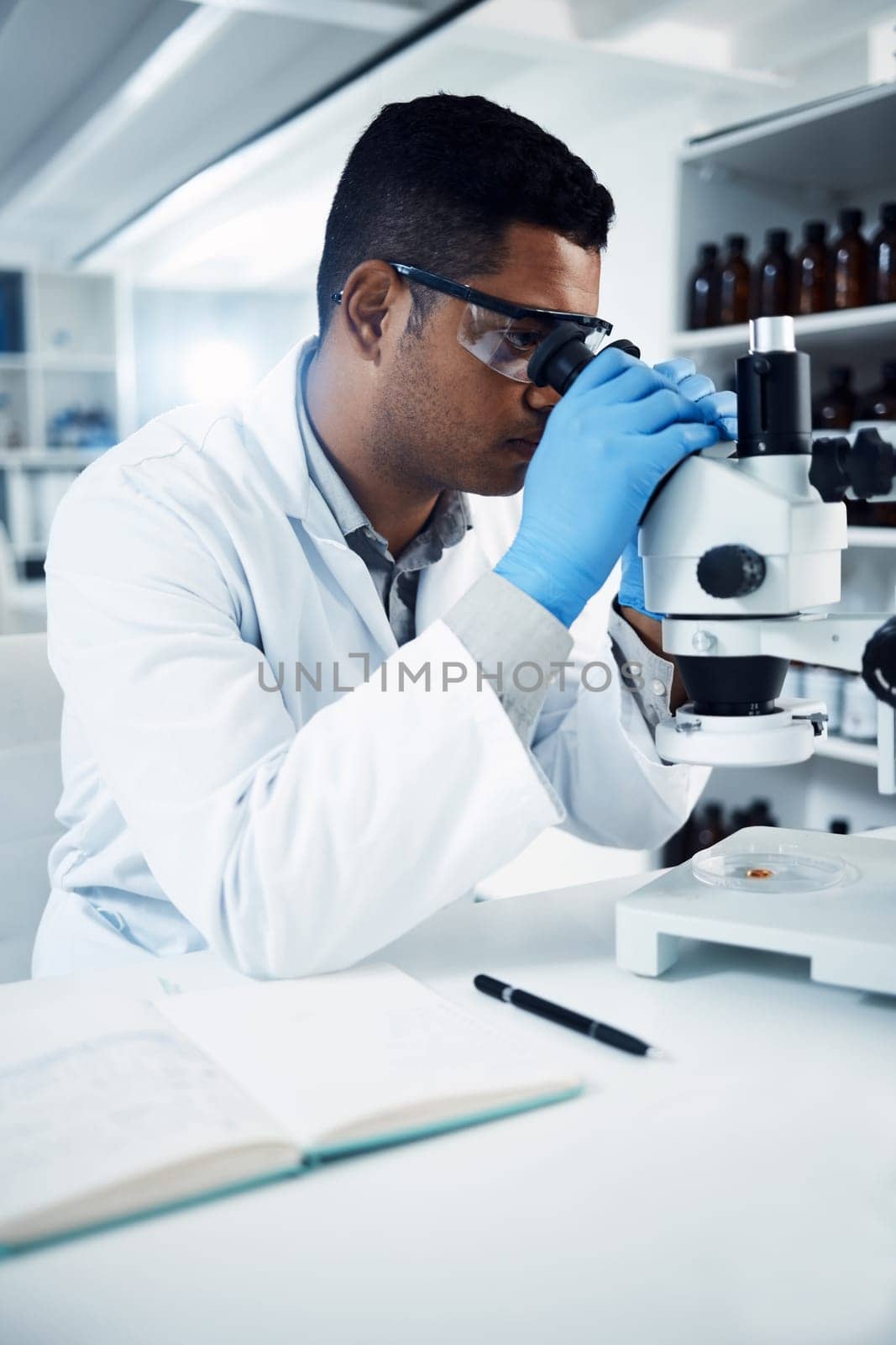 Man, scientist and microscope, analysis in laboratory and check DNA sample with science experiment. Male doctor analyze data in lab, scientific innovation for development and medical research.