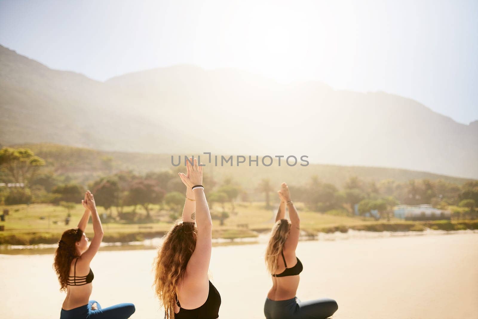 Yoga gives you the means to develop patience. three young women practising yoga on the beach. by YuriArcurs