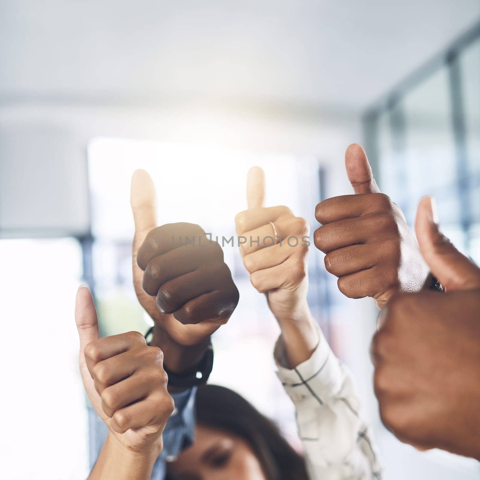 Keep on striving for success. Closeup shot of a group of businesspeople showing thumbs up in an office
