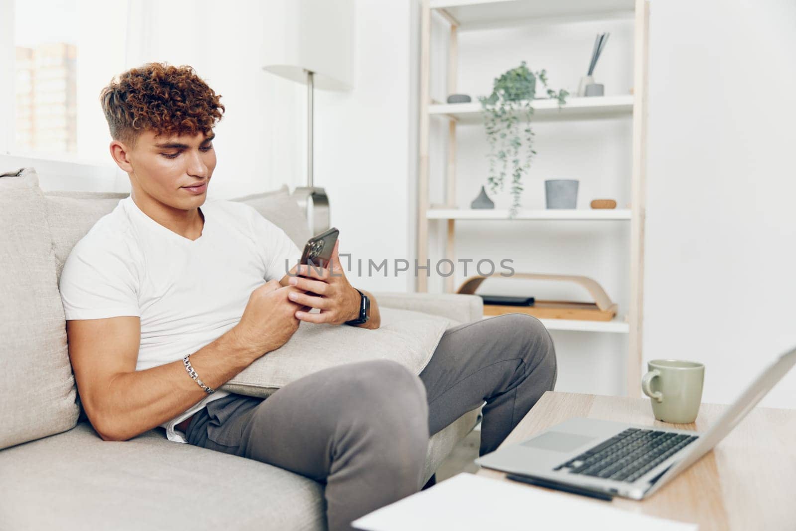 man interior couch using sitting message mobile phone modern communication selfies young student technology blissful blogger