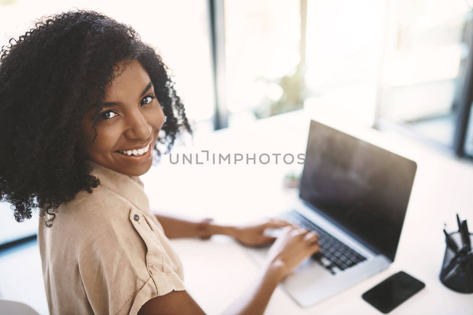 Passion makes all the difference. Portrait of a young businesswoman using a laptop at her desk in a modern office. by YuriArcurs
