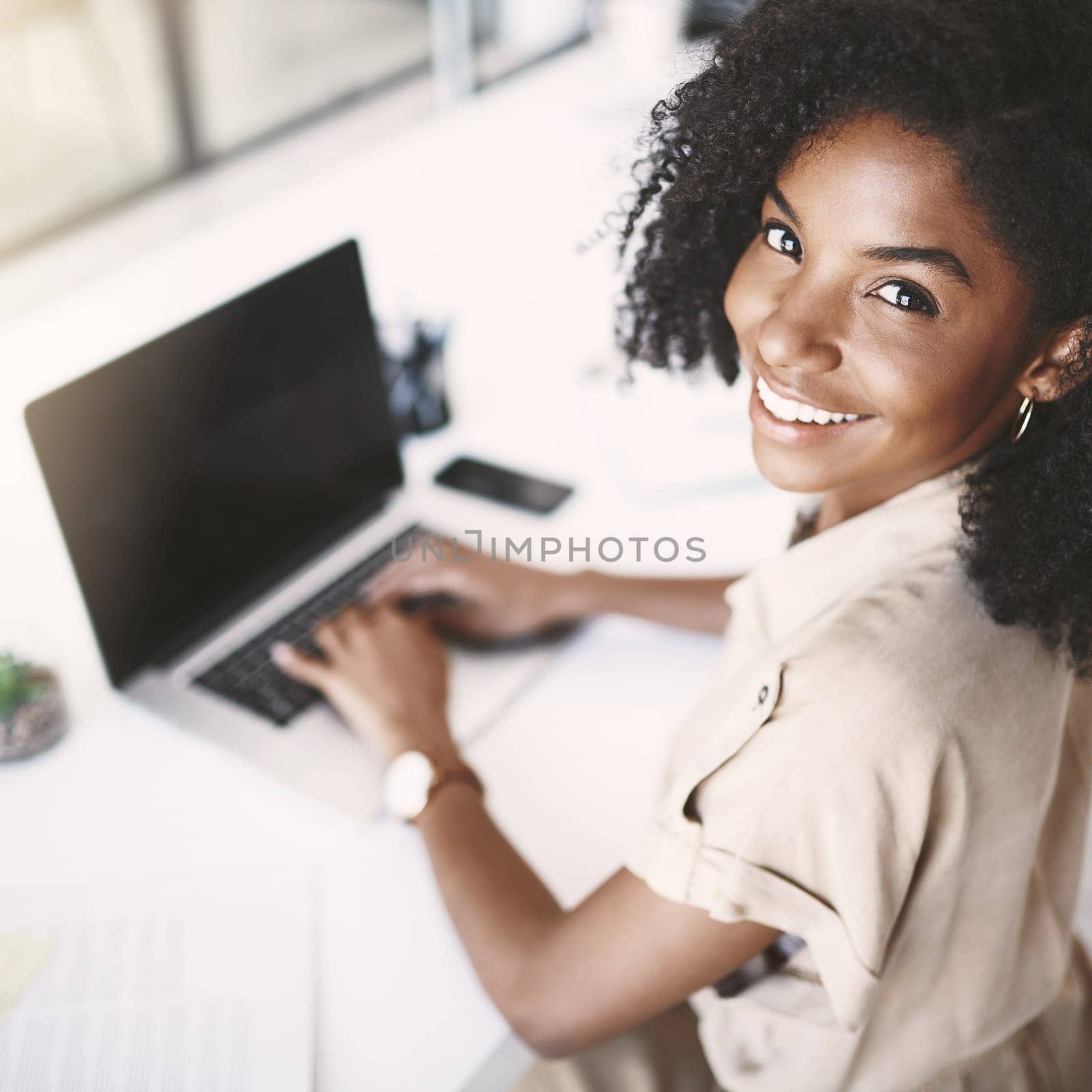 Stay positive, stay productive. Portrait of a young businesswoman using a laptop at her desk in a modern office. by YuriArcurs