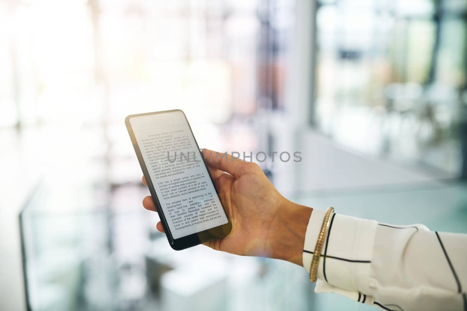 She carries her notes with her for ease of access. Closeup shot of an unrecognizable businesswoman using a cellphone in an office