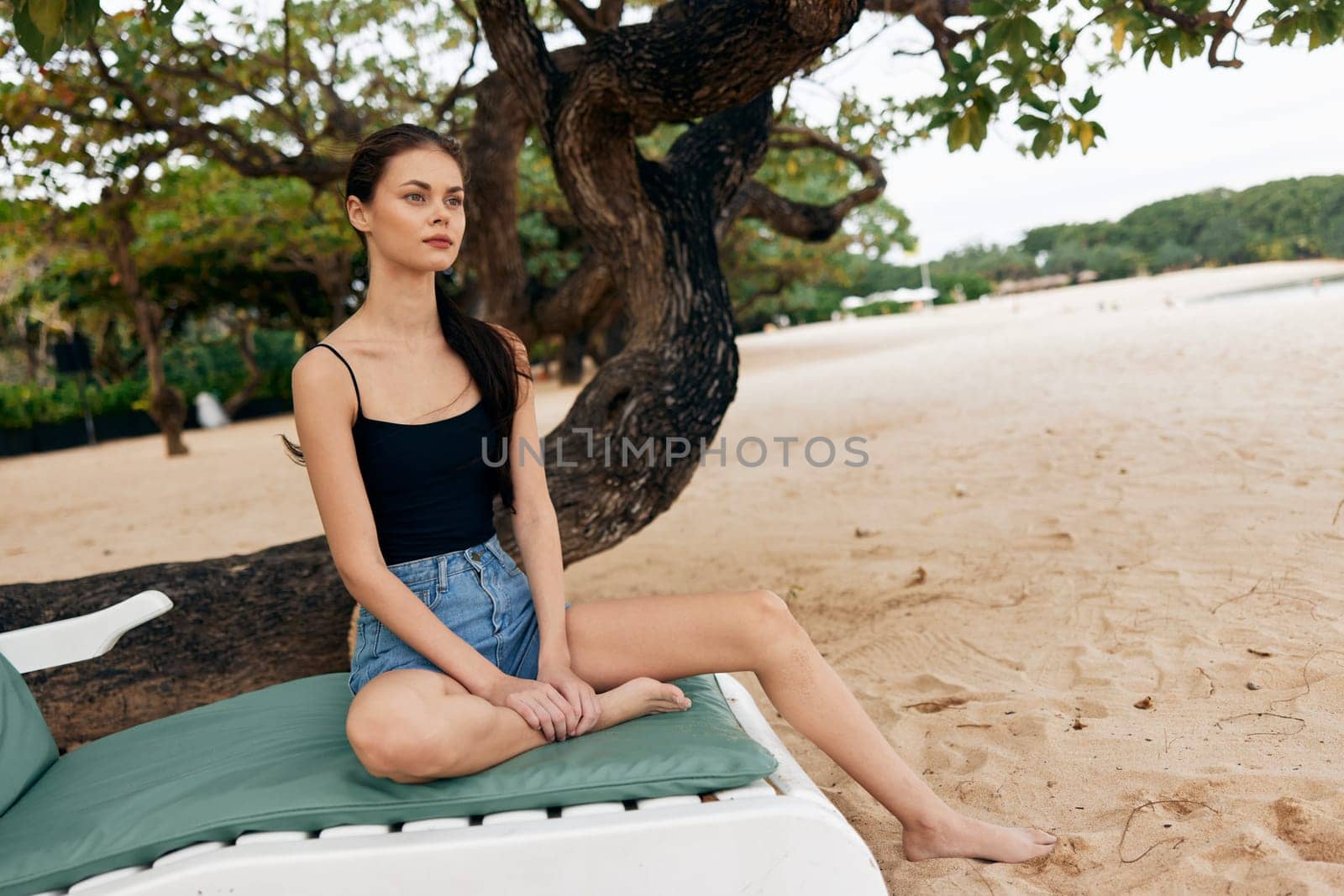 woman young sea lying beach ocean bikini chair resting holiday rest sand tan smiling attractive lifestyle resort vacation sitting travel sunbed