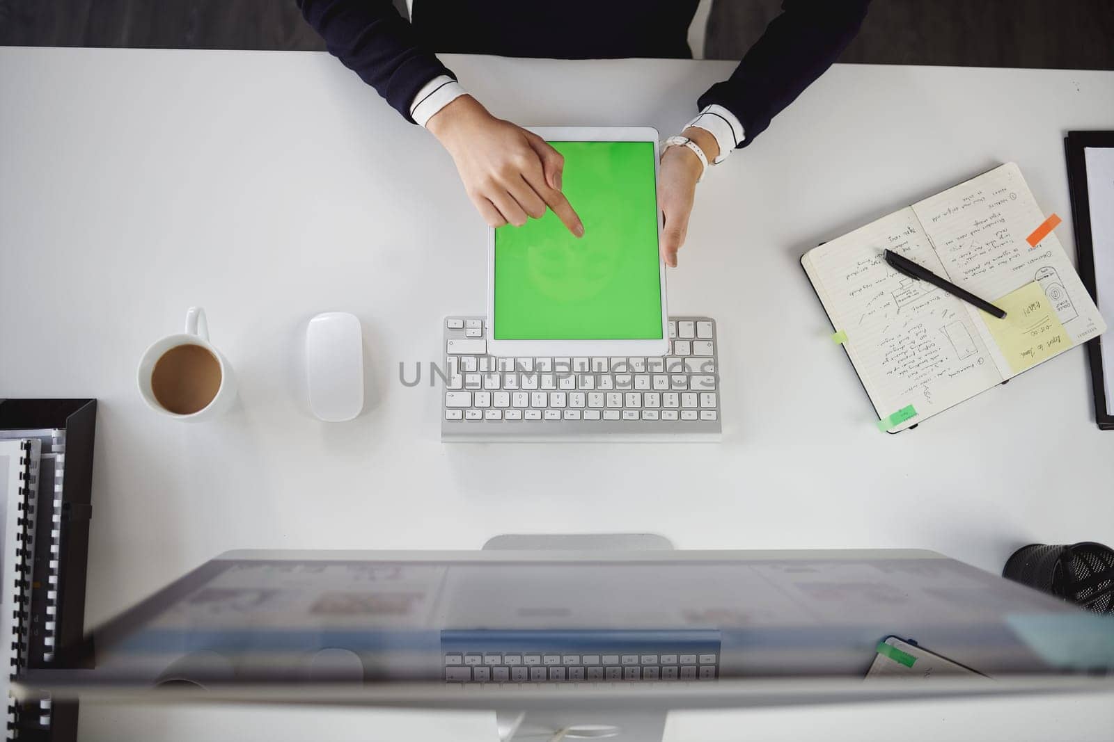 Where would we be without technology. Aerial shot of an unrecognizable young businesswoman sitting at her desk and using her tablet in a modern office. by YuriArcurs