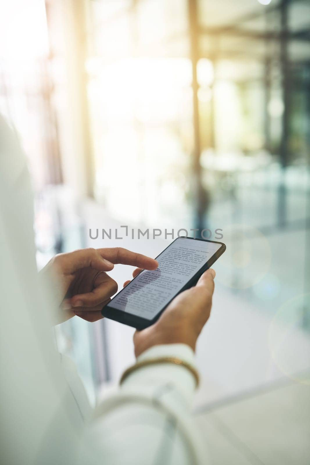 For quick access to all your business data. Closeup shot of an unrecognizable businesswoman using a cellphone in an office. by YuriArcurs