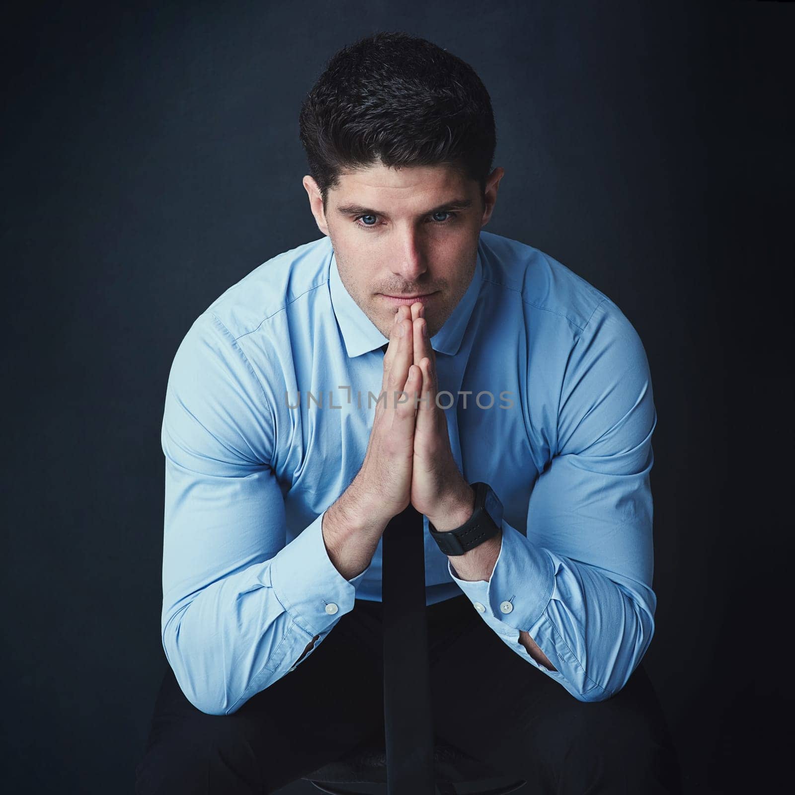 You are bigger than your fears held in your mind. Studio shot of a young businessman looking thoughtful against a dark background. by YuriArcurs
