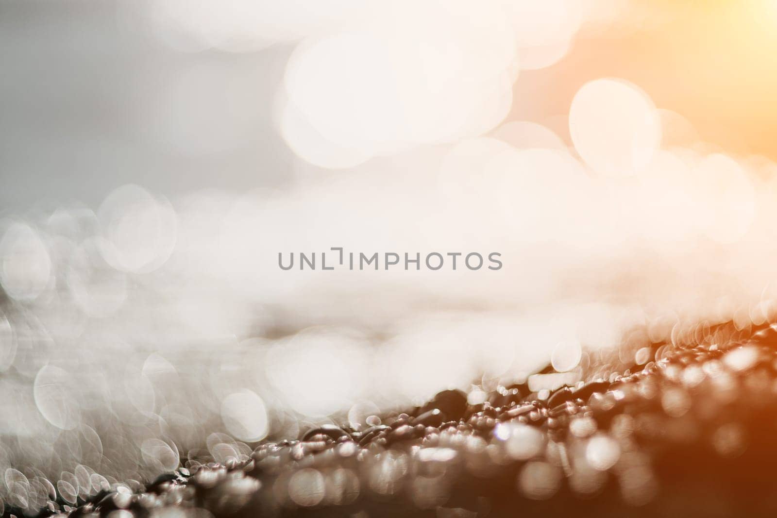 Abstract nature summer ocean sunset sea background. Small waves on water surface in motion blur with bokeh lights from sunrise. Holiday, vacation and recreational background concept. by panophotograph