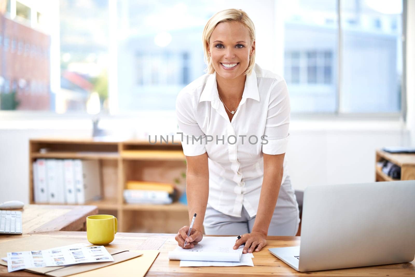 Happy, smile and portrait of a businesswoman in her office writing on paper for startup planning. Confidence, success and professional female hr manager working on a company report in the workplace