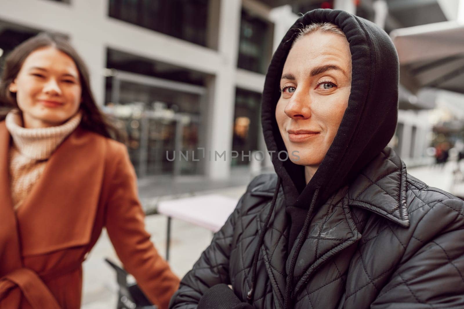 Two women in autumn outside in the city close up