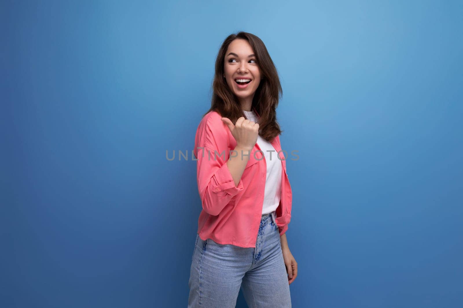 long-haired brunette young adult in a shirt with cheerful emotions on an isolated background.
