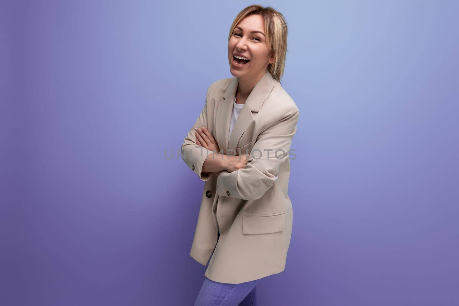positive 30 year old woman in a jacket with blond hair on a studio background with copy space by TRMK