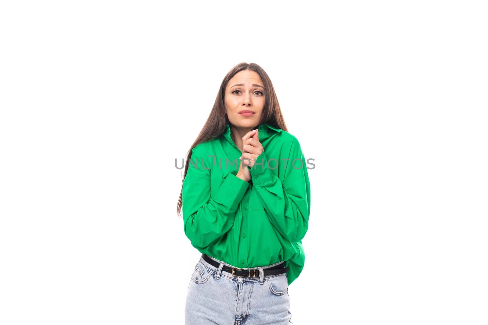 modest well-groomed brunette long-haired young woman in a green shirt on a white background with copy space.