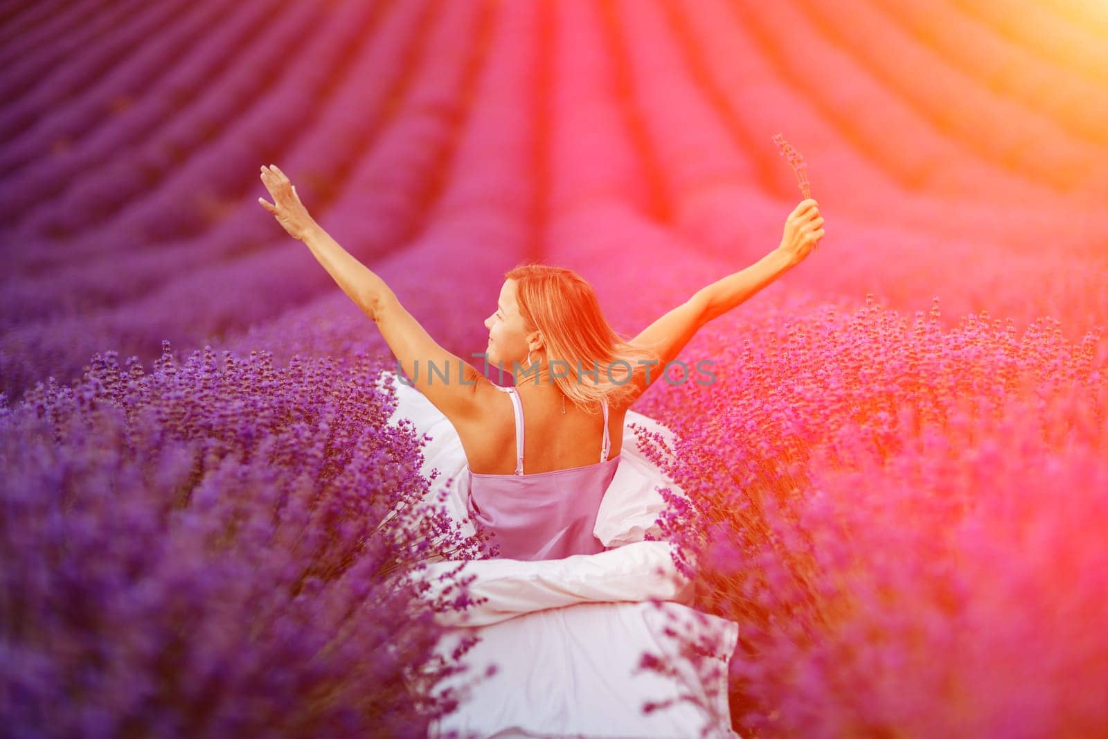 Woman lavender field. A middle-aged woman sits in a lavender field and enjoys aromatherapy. Aromatherapy concept, lavender oil, photo session in lavender by Matiunina