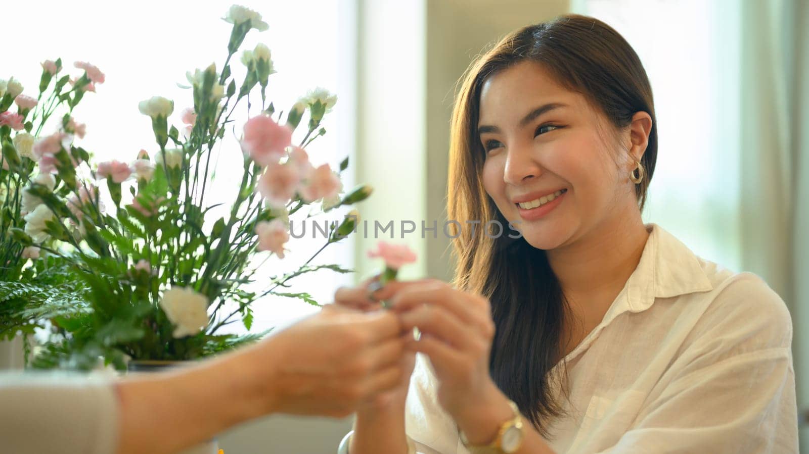 Attractive adult asian woman giving flower to her mother. Happy mother's day, love and family concept.