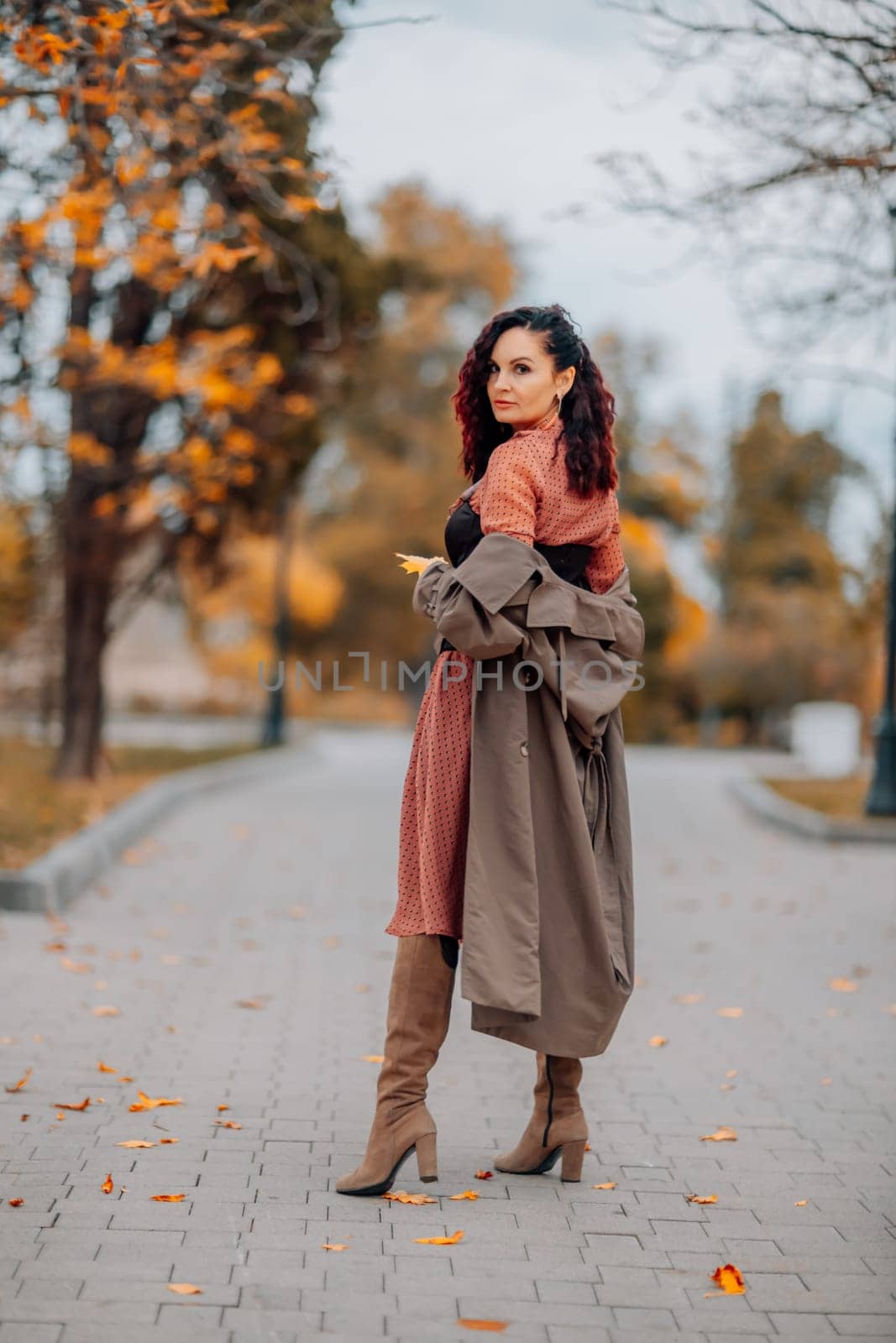 A woman walks outdoors in autumn, enjoys the autumn weather