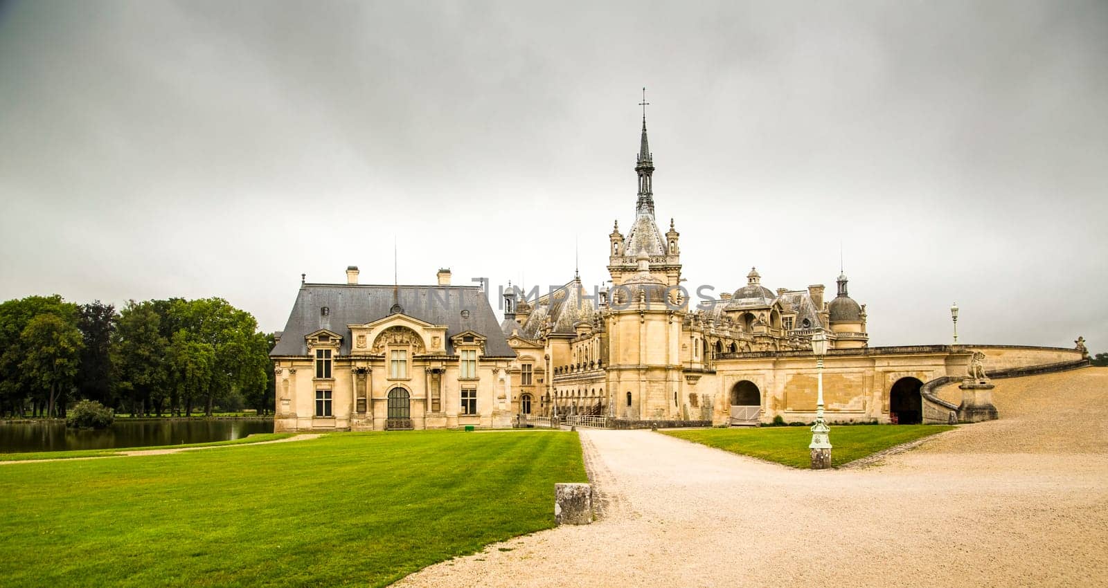 Chantilly, France, 08,26,2021: Panoramic view of the Château de Chantilly with light clouds in the sky.