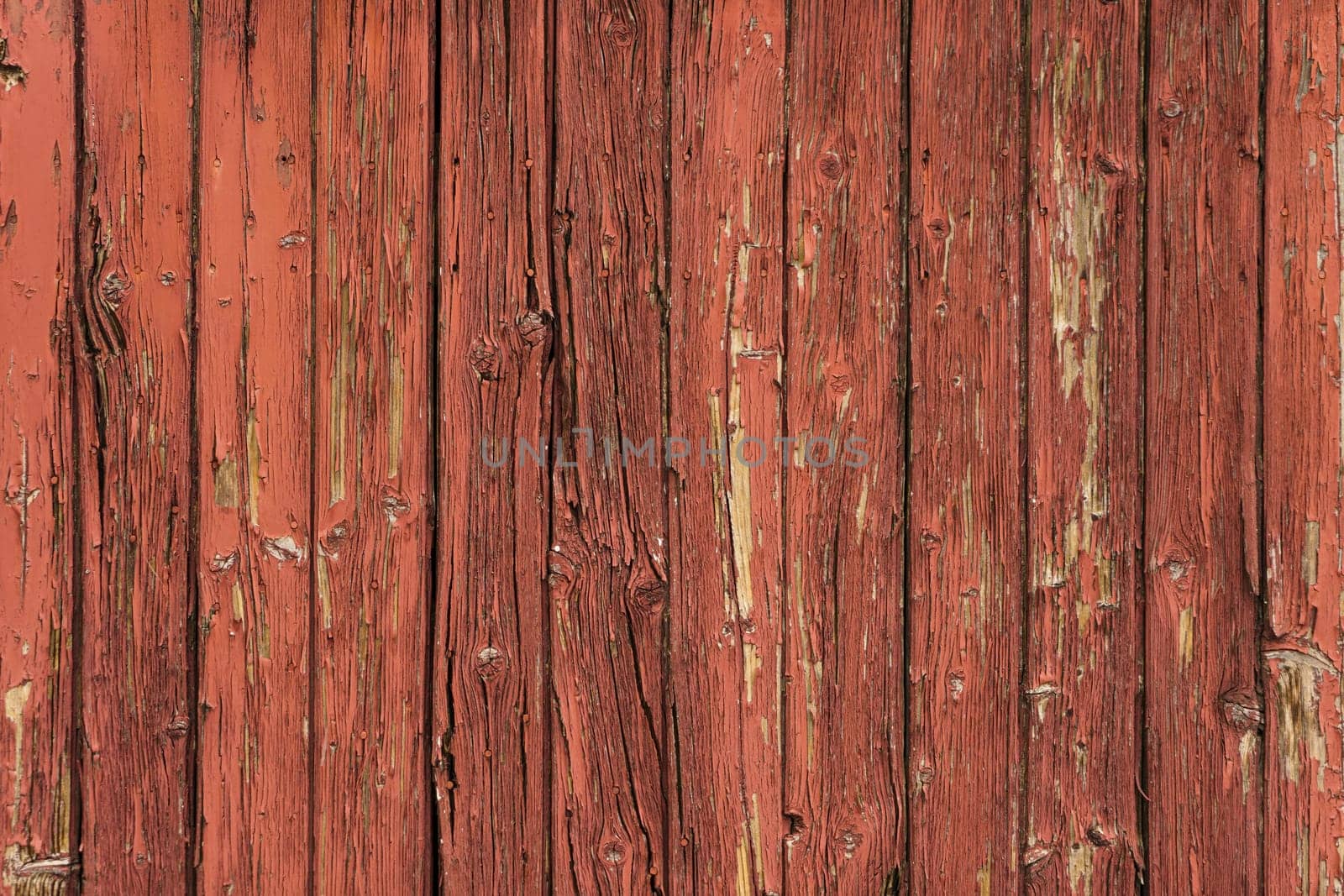 Detail of antique wooden door in red tones, with lots of texture and pickled paint. by csbphoto