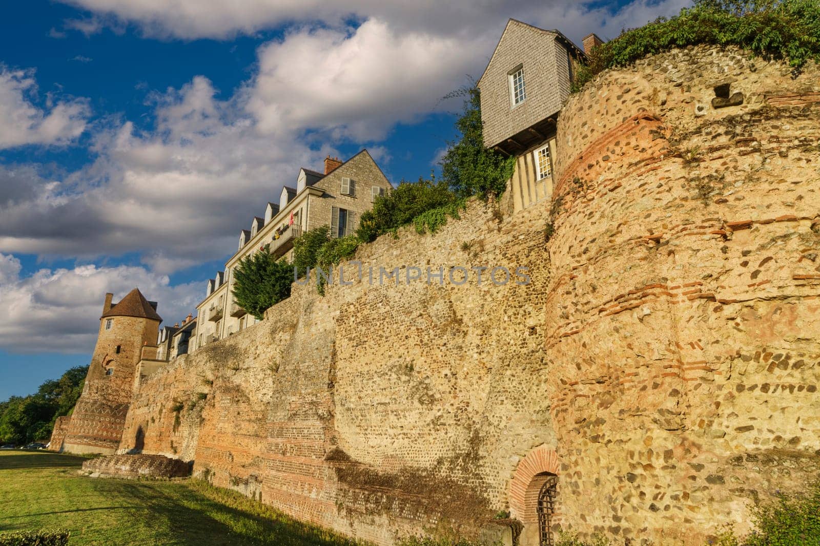 View of the ancient Gallo-Roman wall of Lemans in France, built with stones in warm tones.