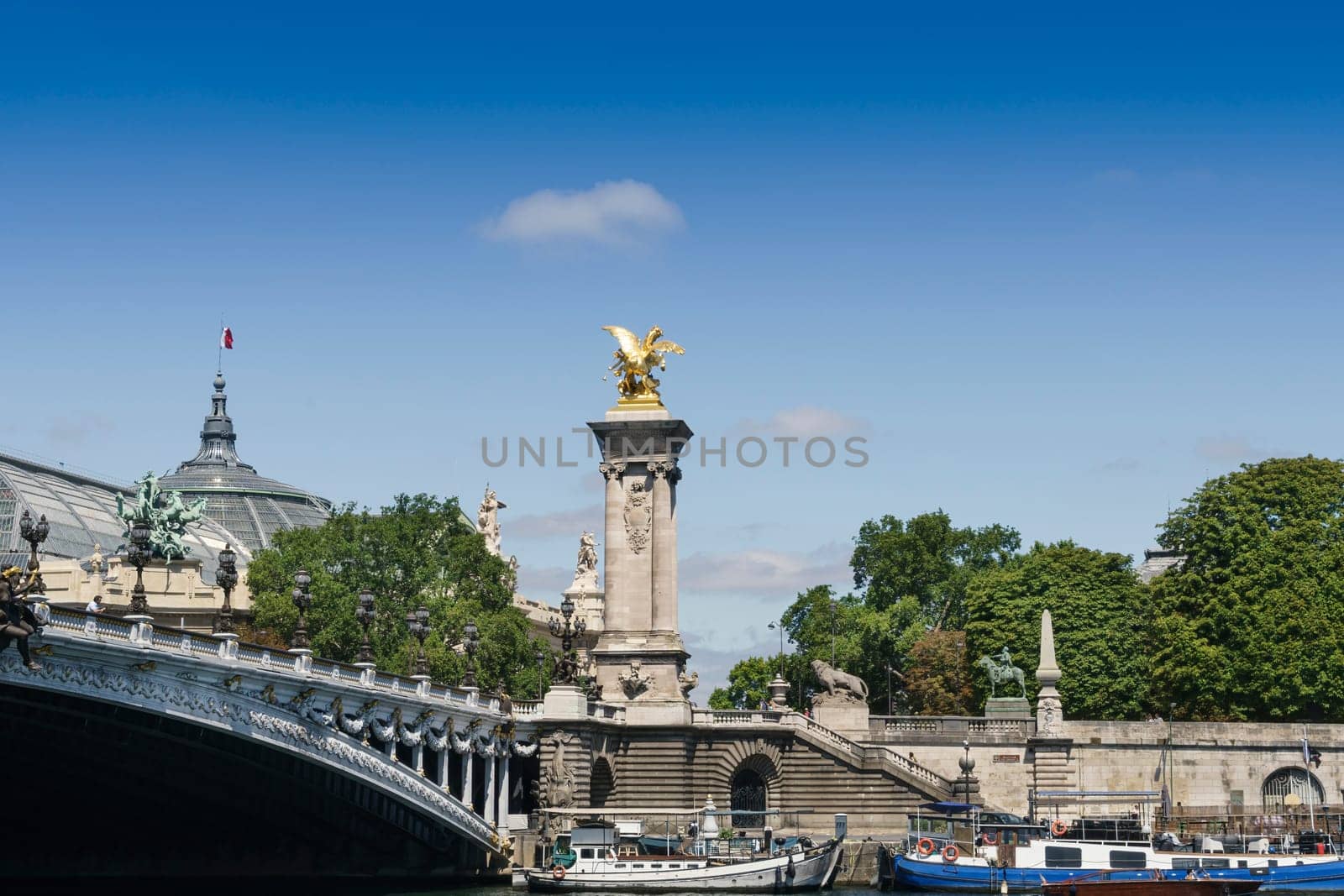 View of the Alexander III bridge over the Seine river, with its golden sculptures with clear blue sky and copy space.