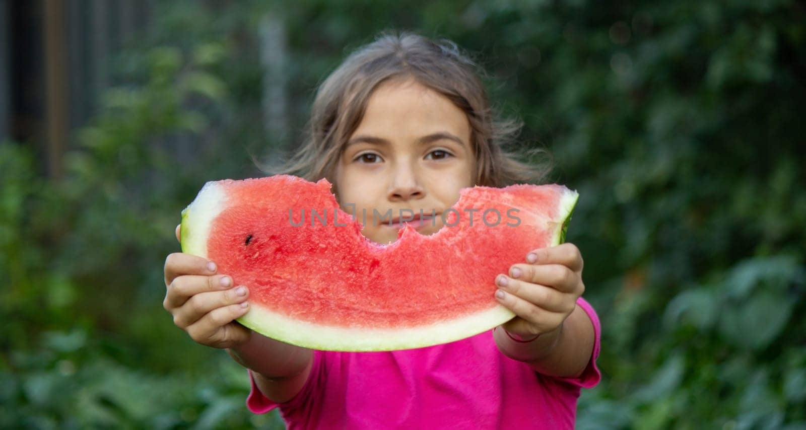 A child eats a watermelon. Selective focus. Nature