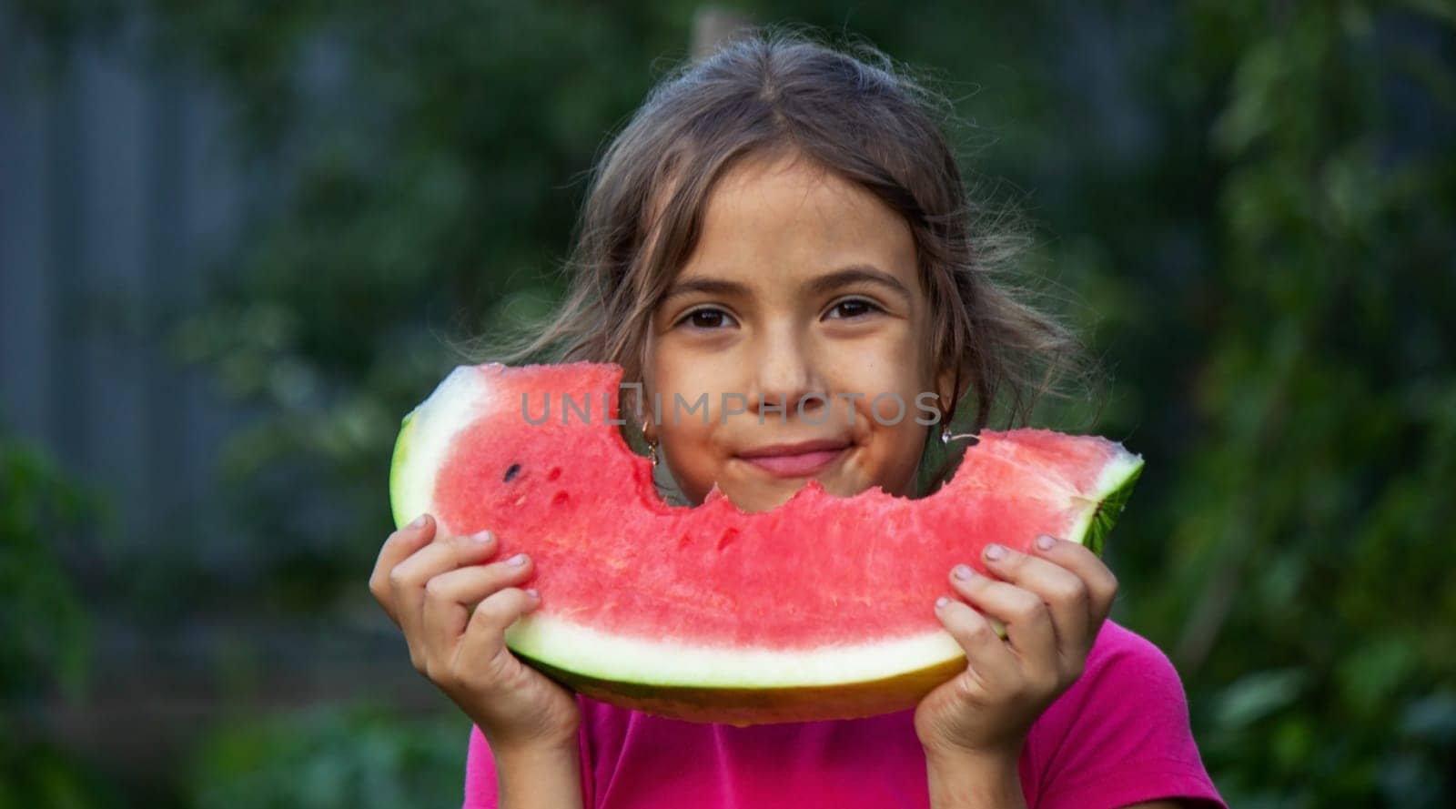 A child eats a watermelon. Selective focus. Nature