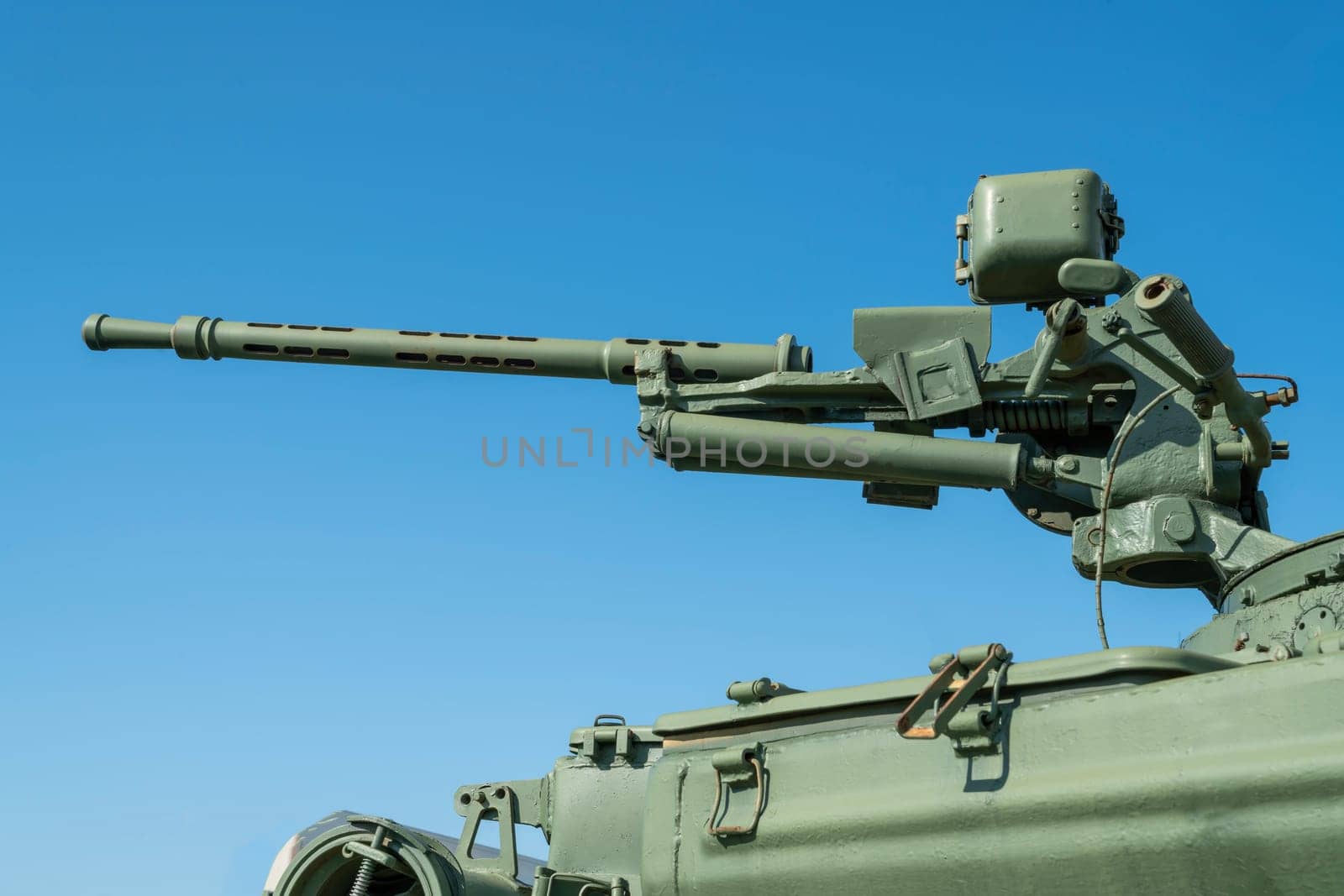 a machine gun on a tank turret against a blue sky background by roman112007