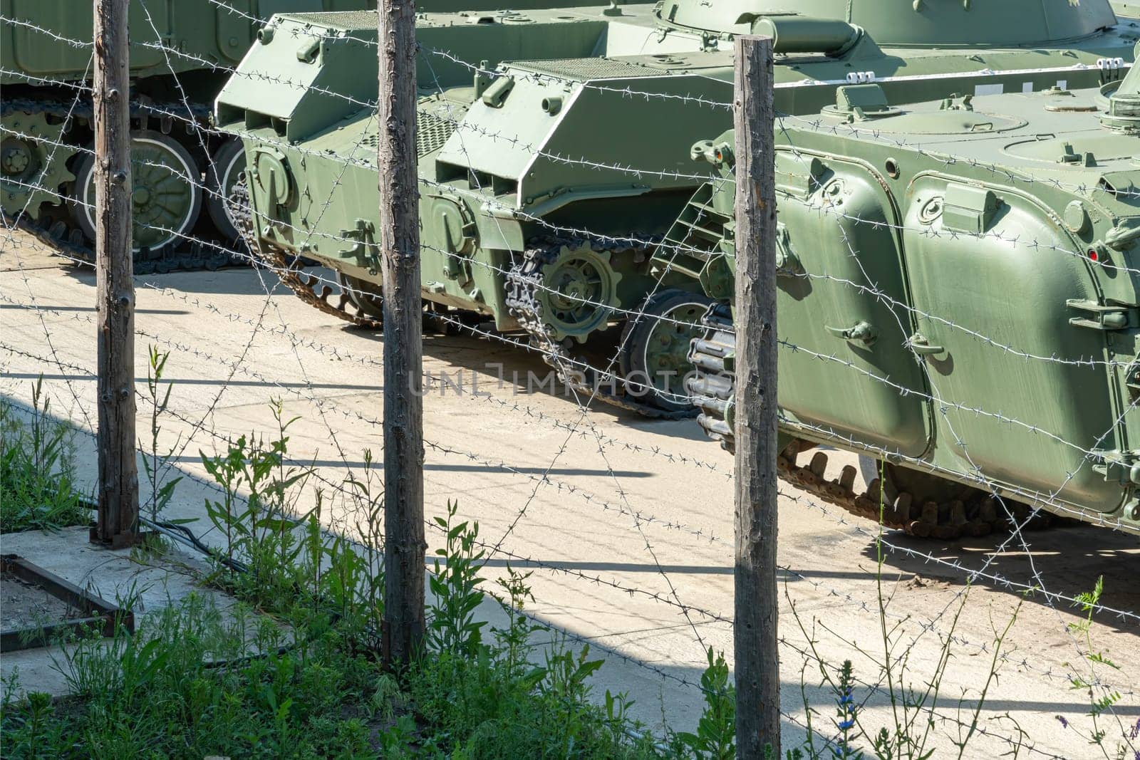 military armored vehicles behind a barbed wire fence. photo