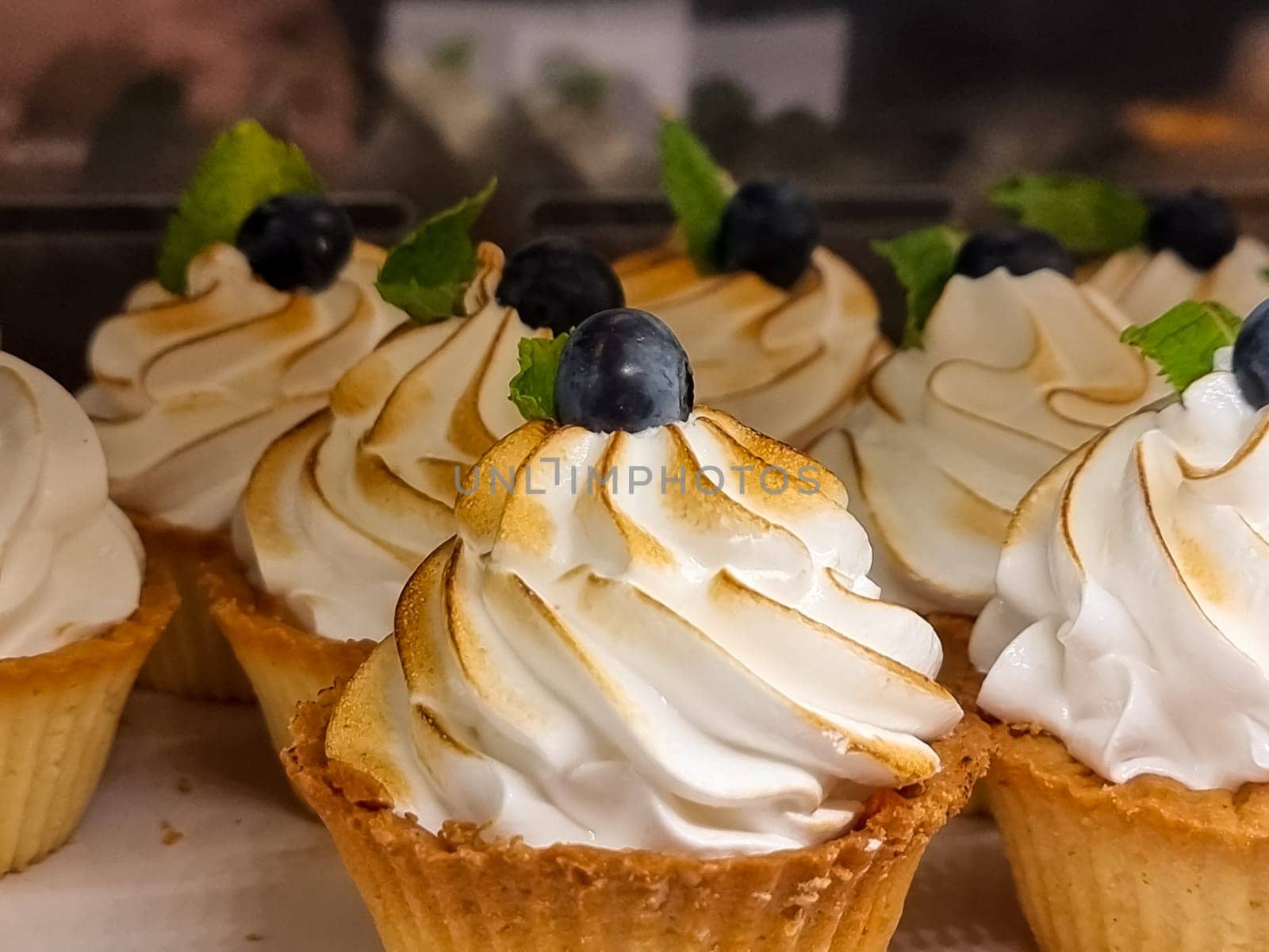 Mini cakes with berries and fruits close up. raspberry, blueberry and kiwi. delicious small tarts