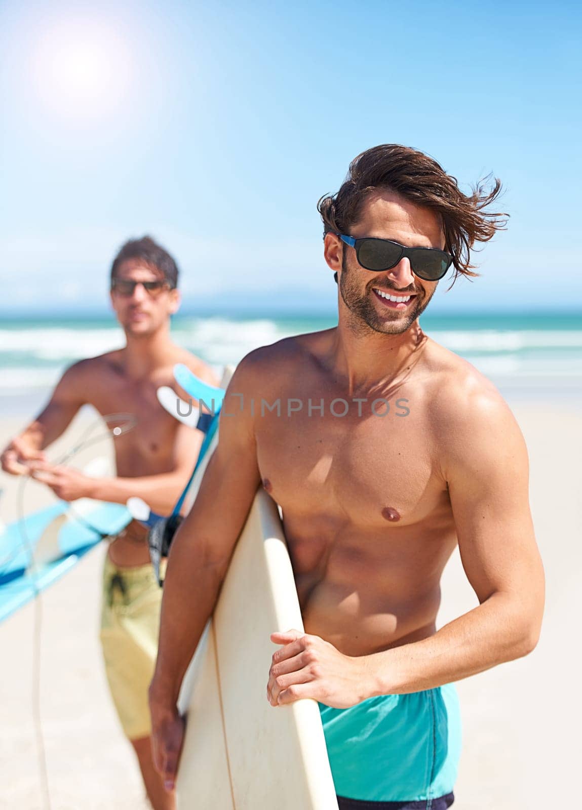 Beach, travel and man surfing friends outdoor together for summer vacation or holiday trip overseas. Surf, sea or fun with a shirtless young male surfer in sunglasses and friend bonding on the coast.