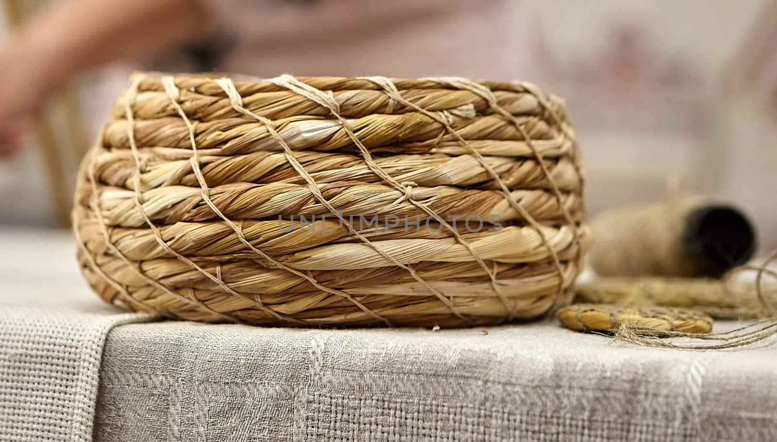 Weaving in progress, a plate of grass. Basket woven from grass. Rural still life.
