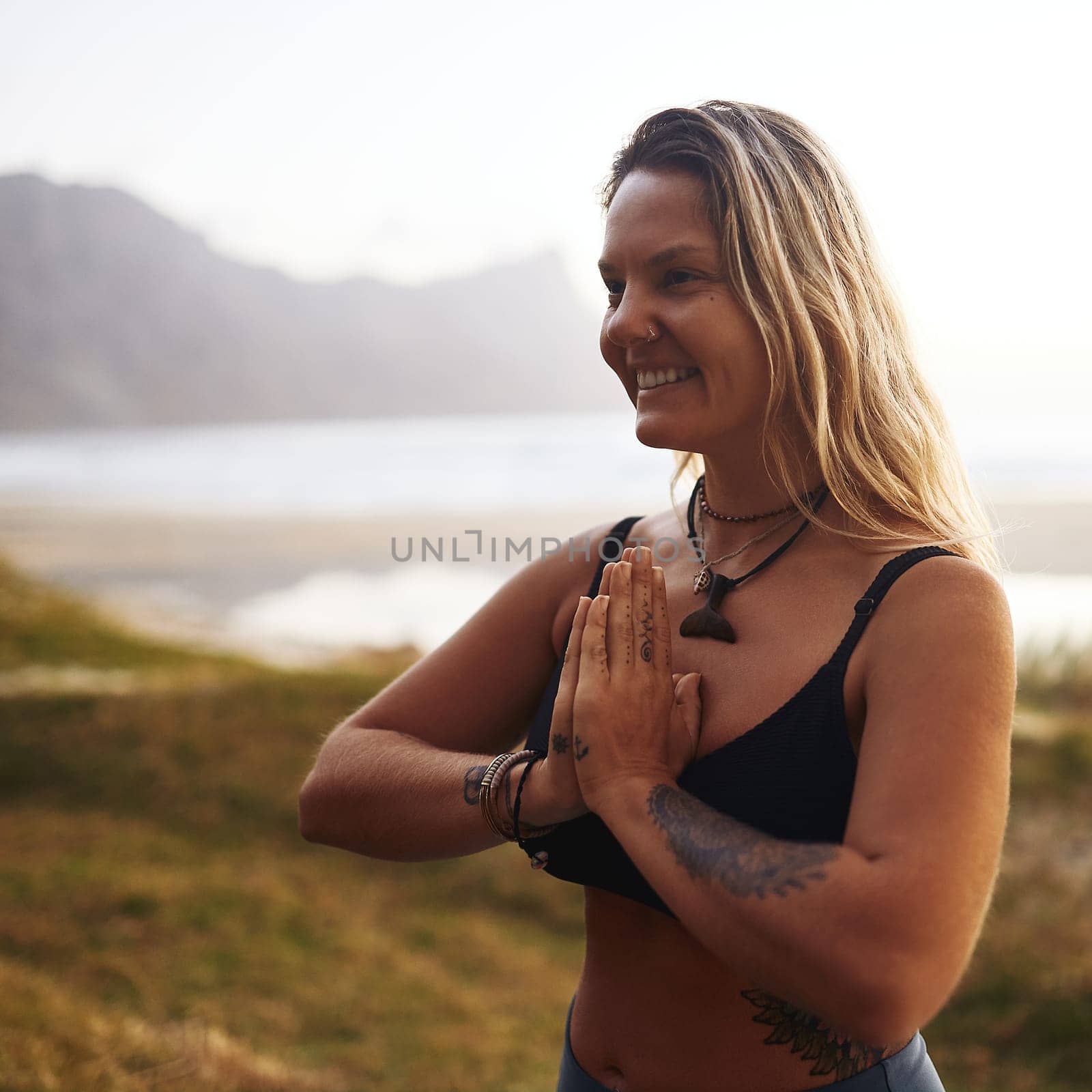 You are one yoga session away from a good mood. an attractive young woman standing alone and meditating during a relaxing day outdoors. by YuriArcurs