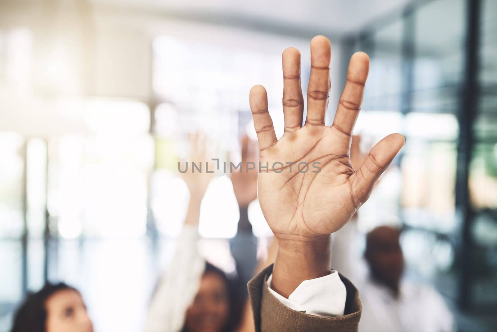 Count us in. Closeup shot of a group of businesspeople raising their hands in an office