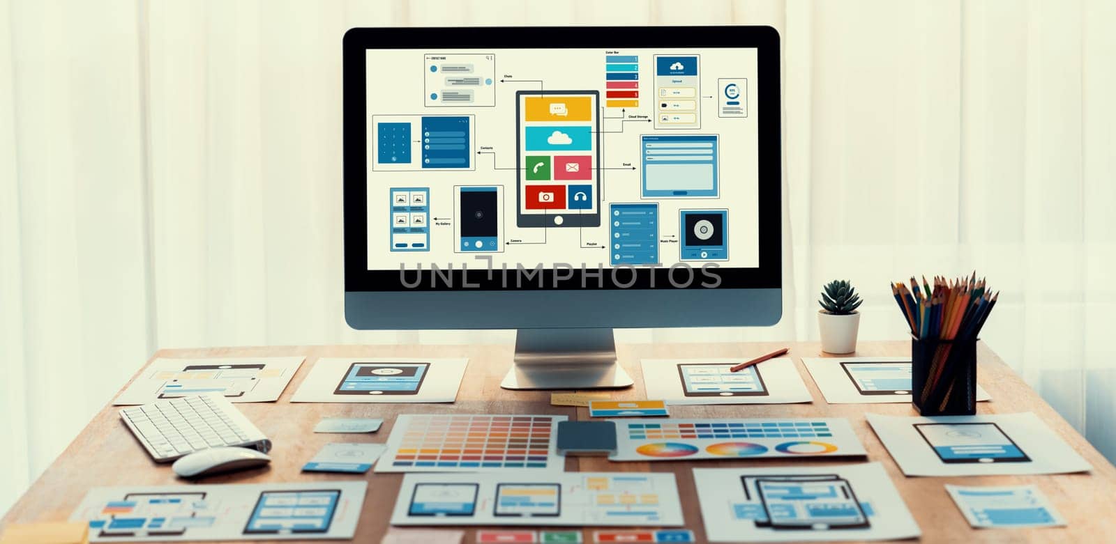 Digital and paper wireframe designs for web or mobile app UI UX display on laptop computer screen. Panoramic shot of developer workspace for brainstorming and design application framework. Scrutinize