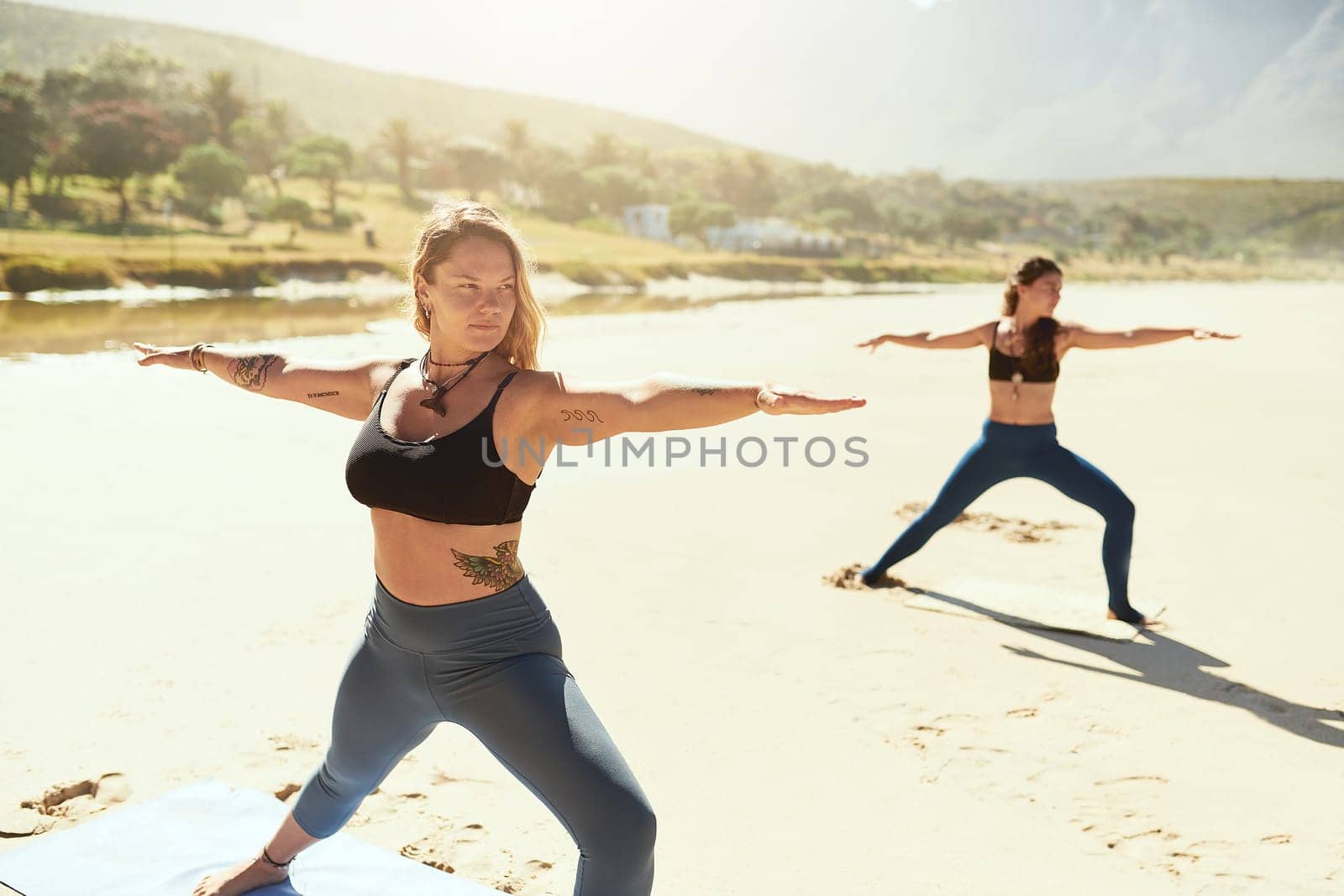 Yoga practice builds your willpower. a beautiful young woman practising yoga on the beach. by YuriArcurs