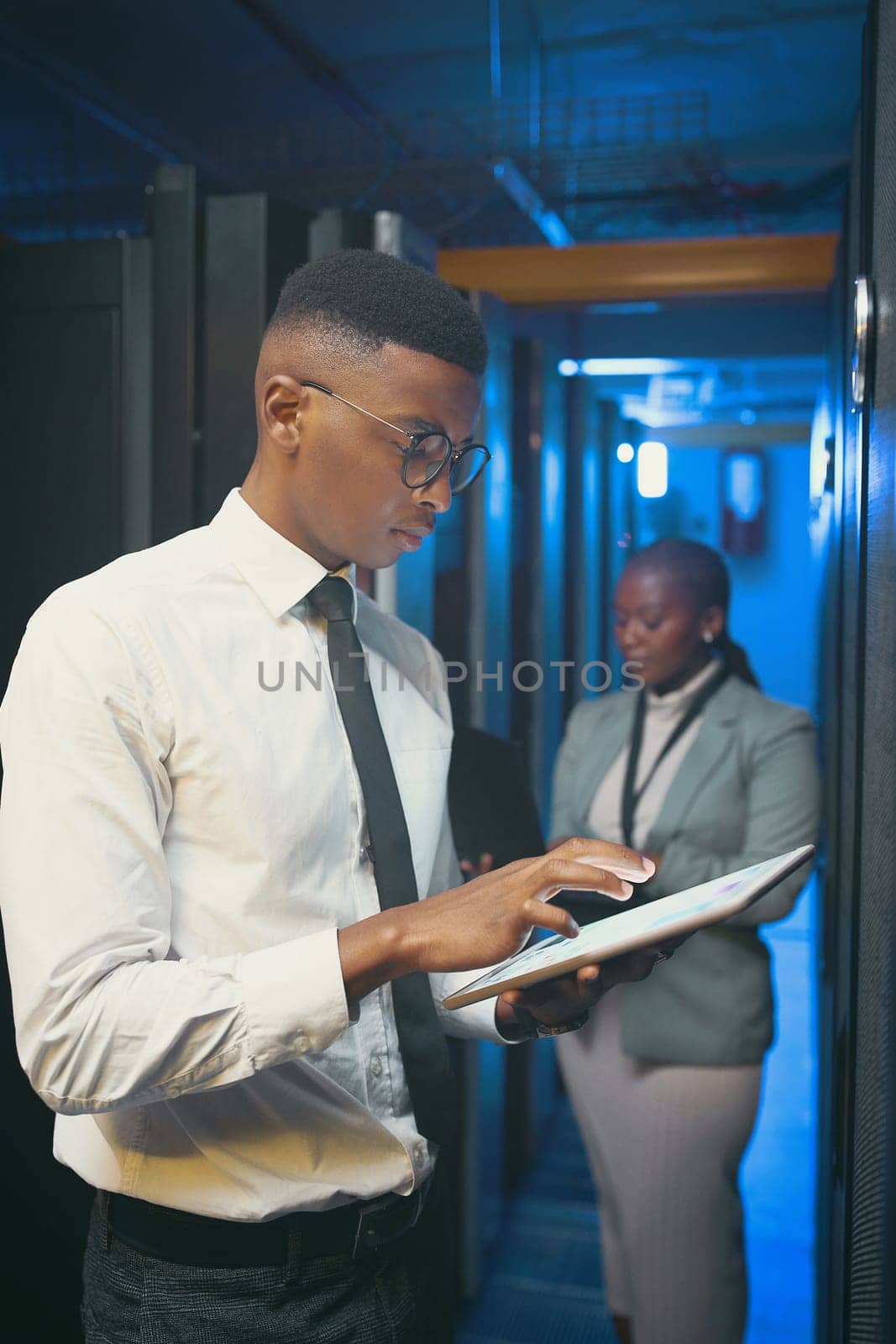 We make sure to have each others back. two young IT specialists standing together in the server room and using technology