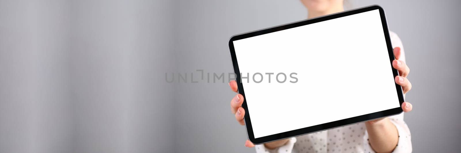 Smiling beautiful woman is holding advertising tablet. Apps and banner for text concept