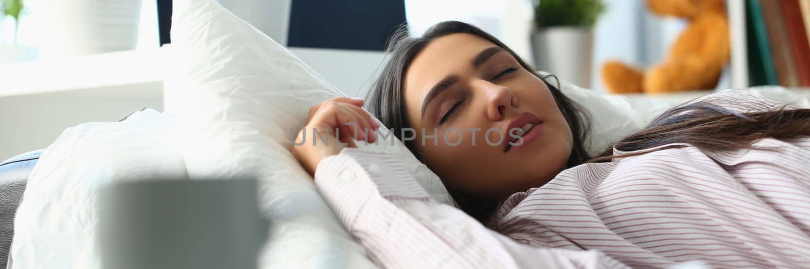 Beautiful young woman sleeping peacefully in bed by kuprevich