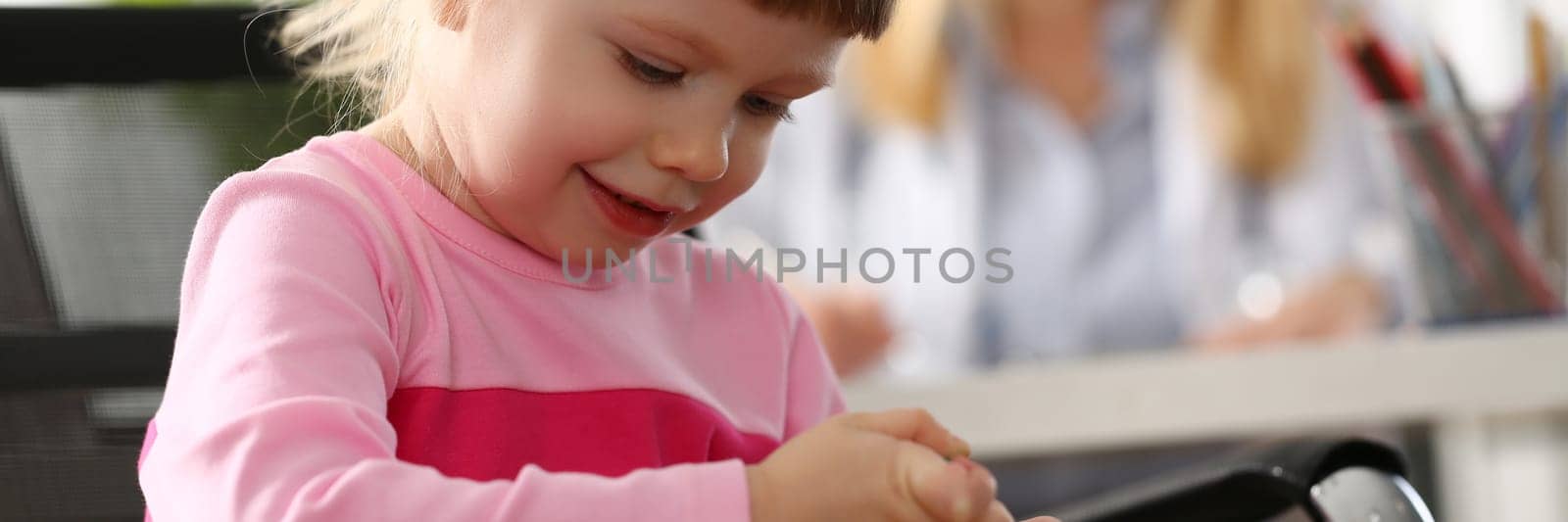 Little girl child makes injection to toy in doctor office. Baby health insurance and assistance pediatrician concept