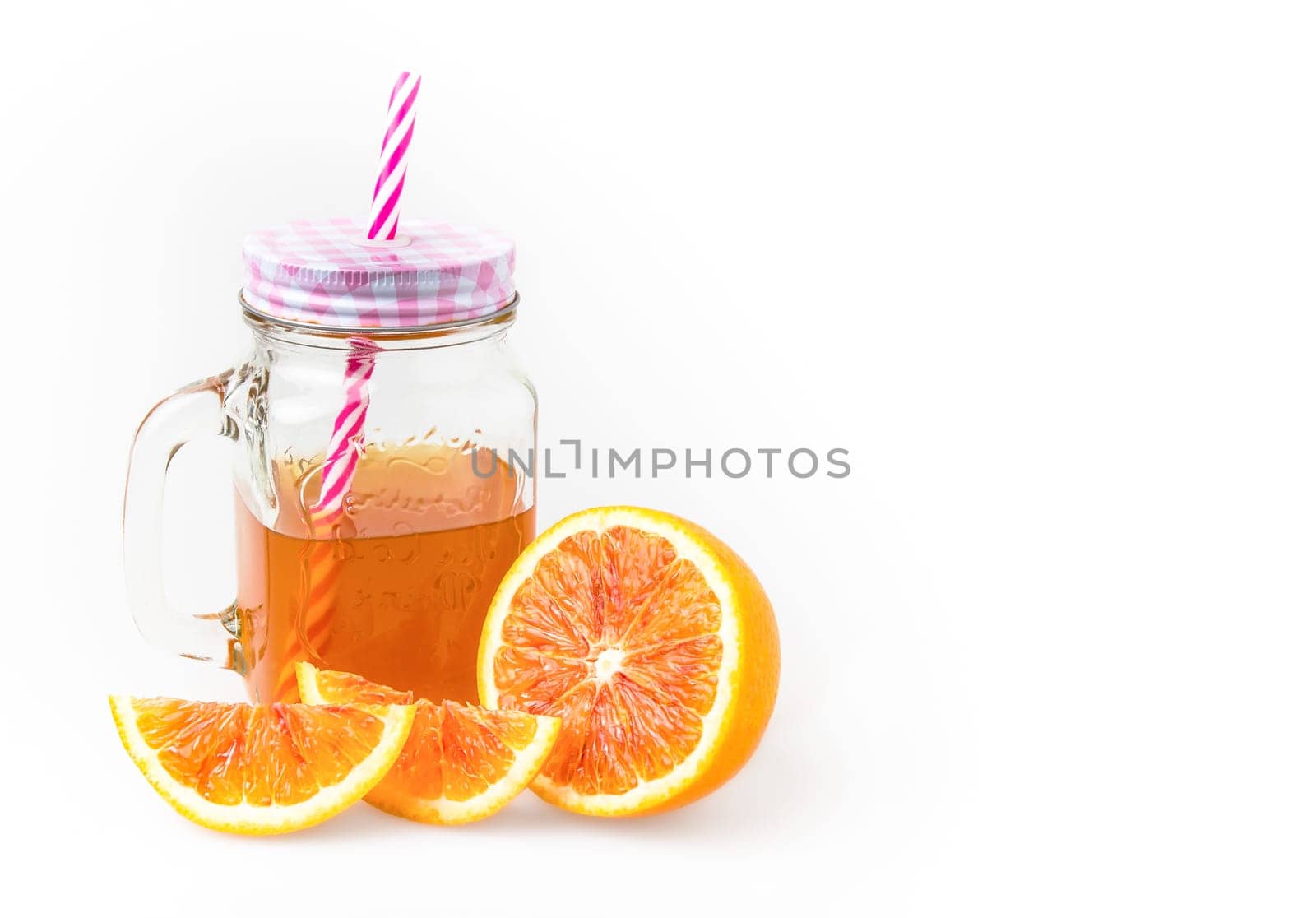 Jug of iced tea with orange slices isolated on white background. Copy space.